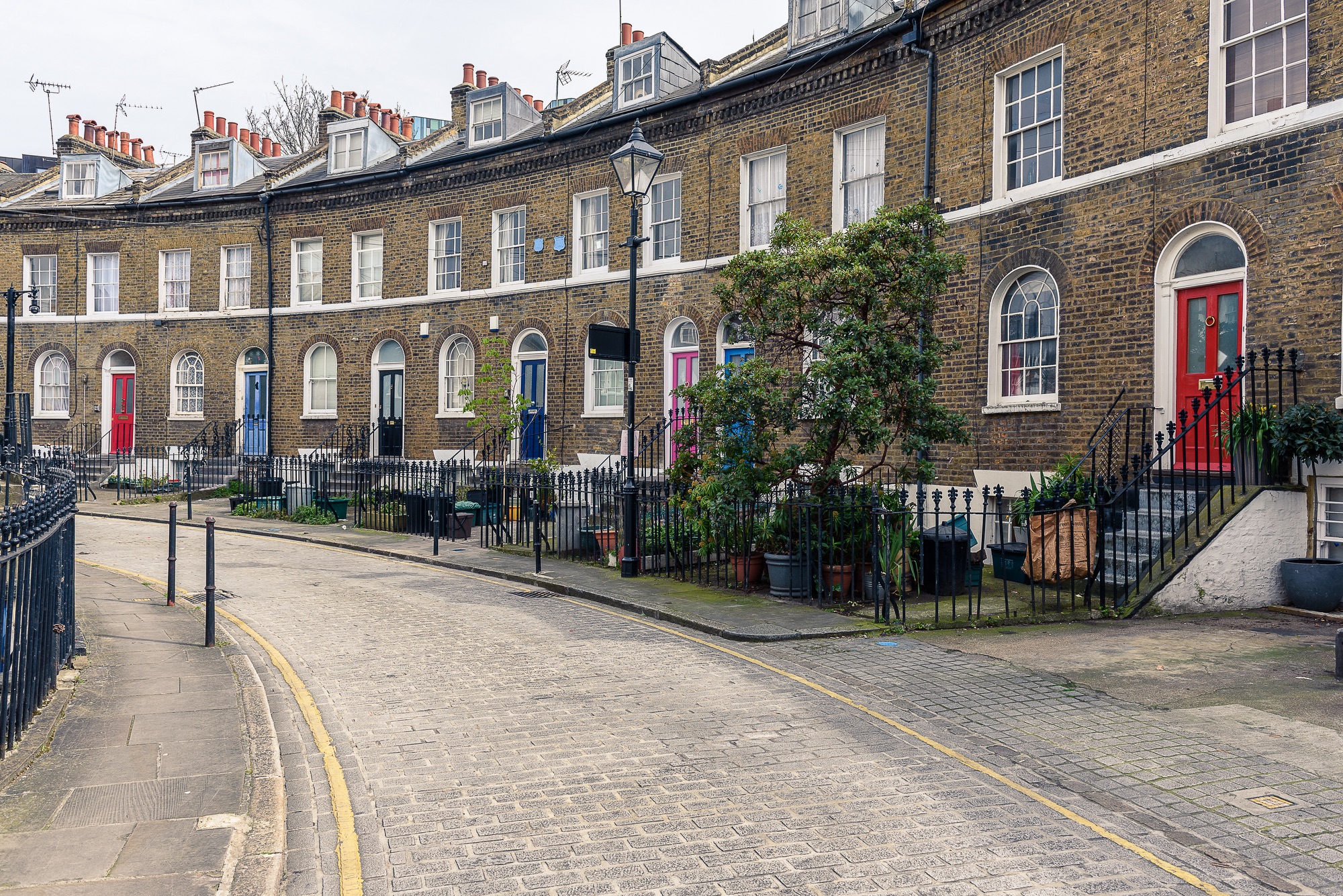 SS_A typical british road with houses in London, with colored doors and fireplaces on the roofs